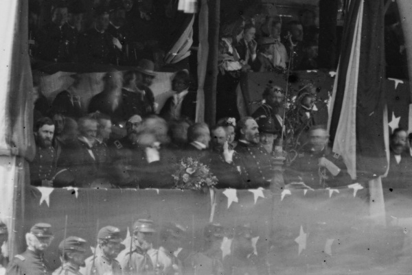 Detail of a photograph of the reviewing stand in front of the White House shows a number of VIPS, including (left to right) Ulysses S. Grant, the blurred figure of Edwiin Stanton, President Andrew Johnson, Wesley Merritt (as commander of the cavalry corps in Philip Sheridan's absence, he sat next to the president as his corps passed), Secretary of the Navy Gideon Welles, Postmaster William Dennison, William T. Sherman, and Quatermaster General Montgomery Meigs (Library of Congress).
